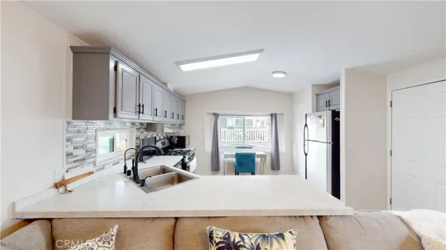 a kitchen with stainless steel appliances granite countertop a sink stove refrigerator and cabinets