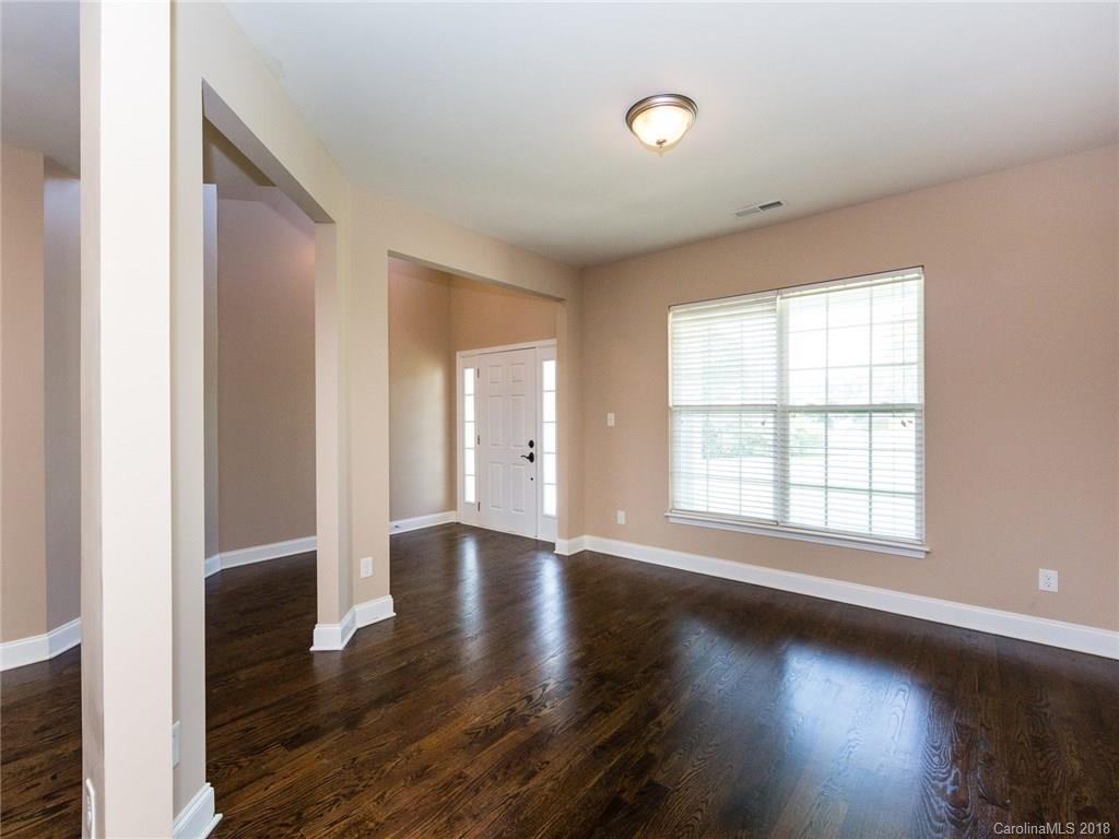 708 Baucom Road Monroe, NC 28110 - Photo 4 of 33 an empty room with wooden floor and windows