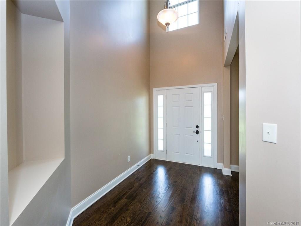 708 Baucom Road Monroe, NC 28110 - Photo 5 of 33 an empty room with wooden floor and windows