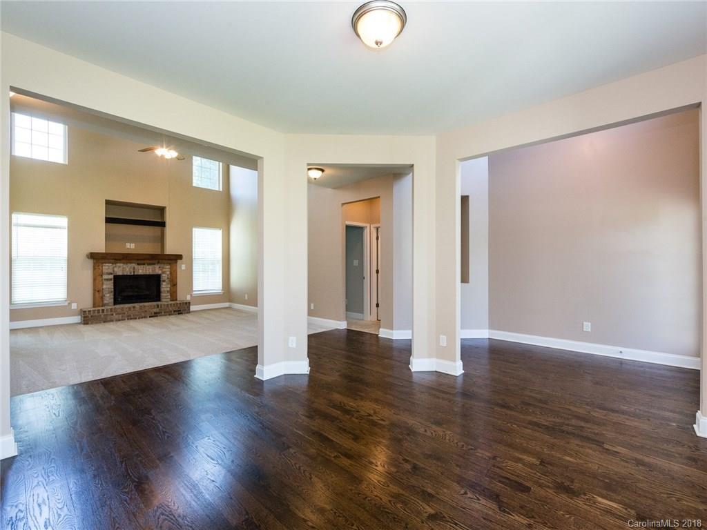 708 Baucom Road Monroe, NC 28110 - Photo 6 of 33 an empty room with wooden floor and fireplace