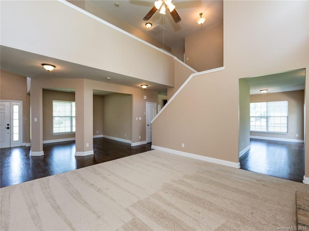 708 Baucom Road Monroe, NC 28110 - Photo 9 of 33 a view of an empty room with wooden floor and a kitchen