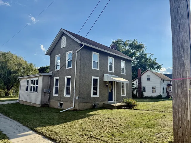 a view of a house with backyard and sitting area