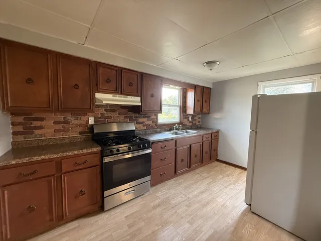a kitchen with stainless steel appliances granite countertop a refrigerator stove and sink