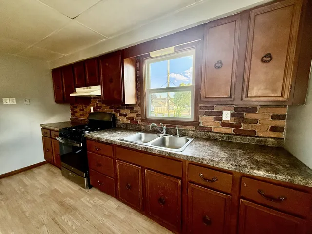 a kitchen with granite countertop a sink cabinets and window