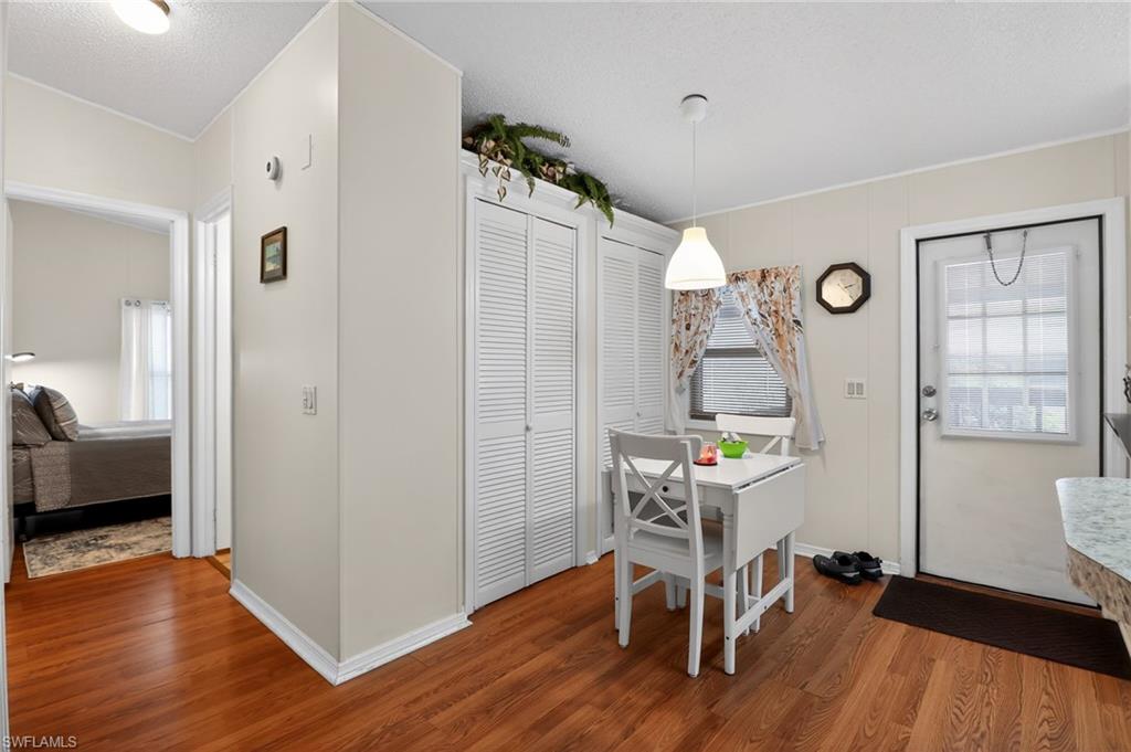 183 Oceans Boulevard, Unit 183 Naples, FL 34104 - Photo 12 of 28 Dining space featuring a textured ceiling and wood finished floors
