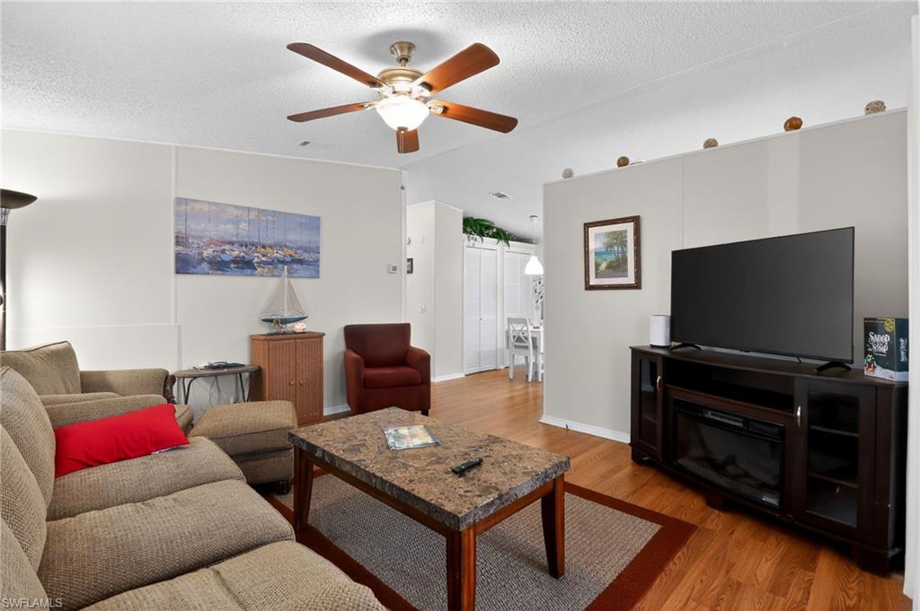 183 Oceans Boulevard, Unit 183 Naples, FL 34104 - Photo 13 of 28 Living area with wood finished floors, ceiling fan, and a textured ceiling