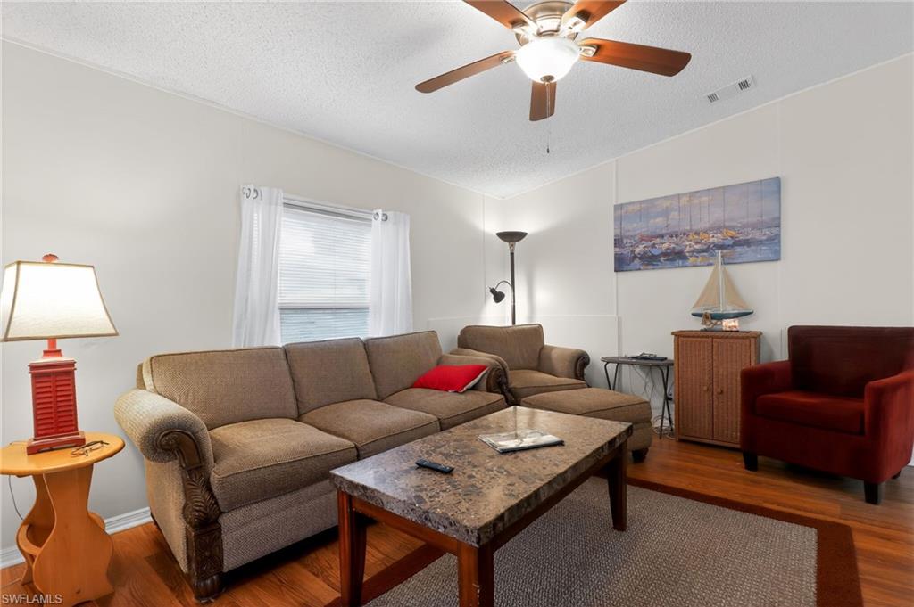 183 Oceans Boulevard, Unit 183 Naples, FL 34104 - Photo 14 of 28 Living area featuring wood finished floors and a ceiling fan