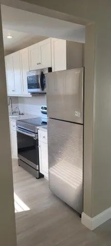 a kitchen with granite countertop cabinets stainless steel appliances and a counter top space