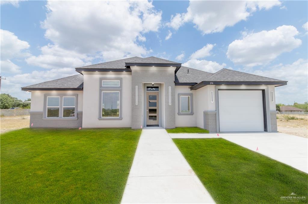 a front view of a house with a yard and garage