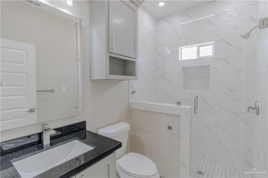 216 Nazareth Street Rio Grande City, TX 78582 - Photo 11 of 14 a bathroom with a granite countertop toilet sink and mirror