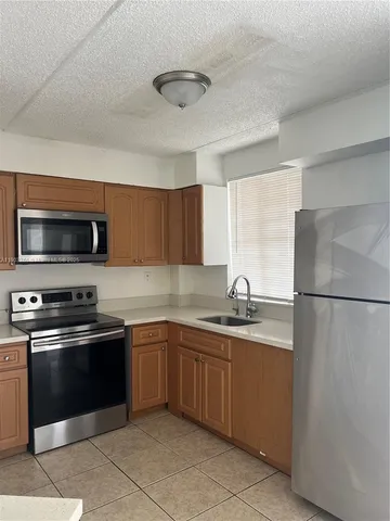 a kitchen with stainless steel appliances granite countertop a sink and a refrigerator
