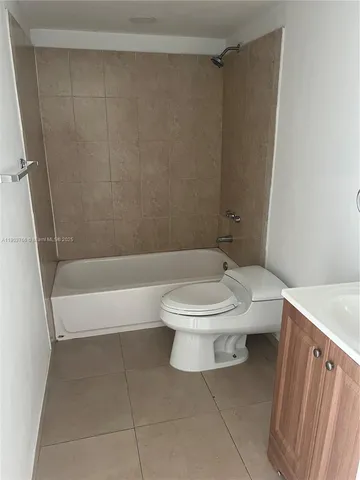 a white toilet sitting next to a bathroom sink and tub