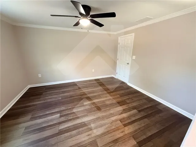 a view of an empty room with wooden floor fireplace and a window