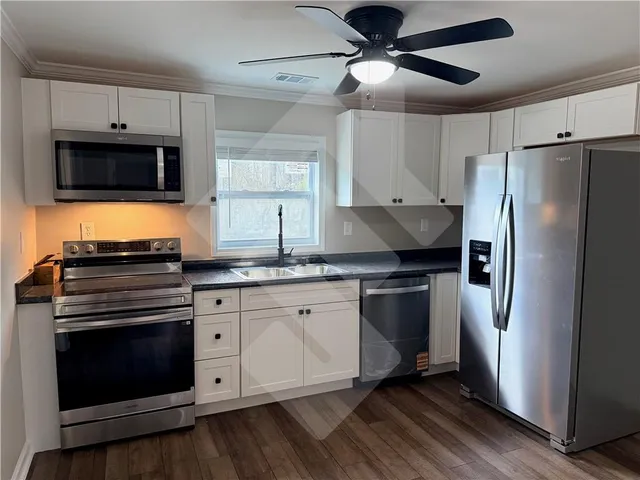 a kitchen with stainless steel appliances a stove microwave and refrigerator