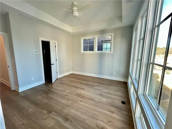 an empty room with wooden floor and a ceiling fan