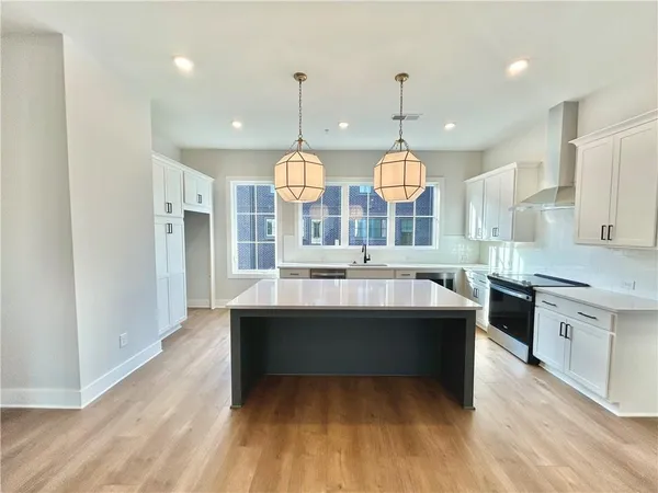 a large kitchen with kitchen island a stove and a wooden floors