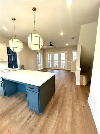 a kitchen with a sink chandelier and wooden floor