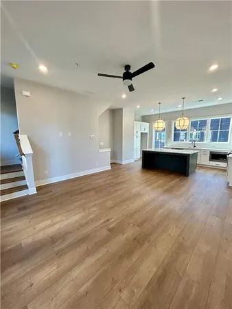 a view of a big room with wooden floor and windows