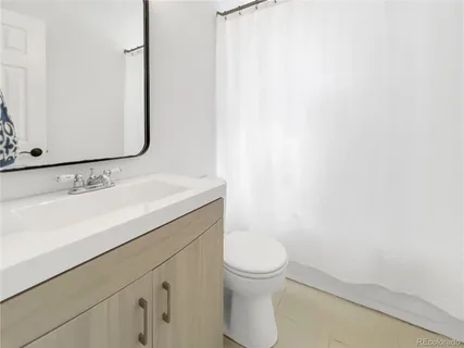 a bathroom with a sink a toilet and mirror