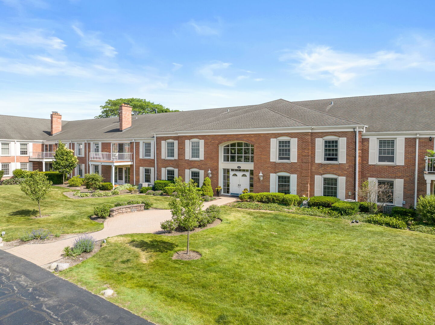 124 Carriage Way Drive, Unit B109 Burr Ridge, IL 60527 - Photo 25 of 31 a front view of a residential apartment building with yard and green space
