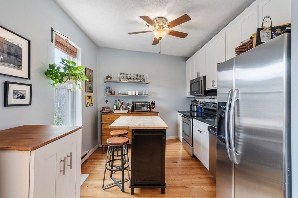 136 Prince Street, Unit 6 Boston, MA 02113 - Photo 3 of 14 a kitchen with kitchen island a counter space a sink appliances and cabinets