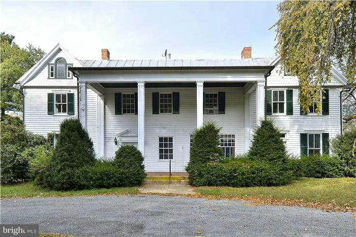 a view of a white house with large windows and a small yard