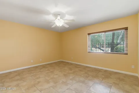 an empty room with windows and fan