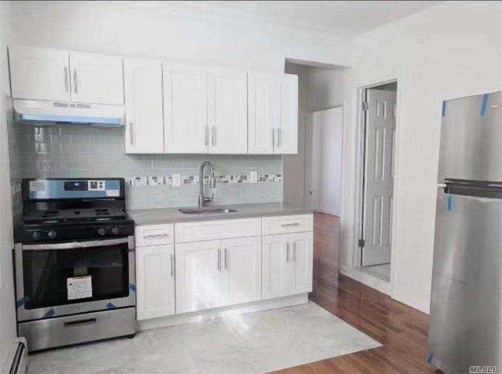 a kitchen with stainless steel appliances granite countertop a stove a refrigerator and a white cabinets