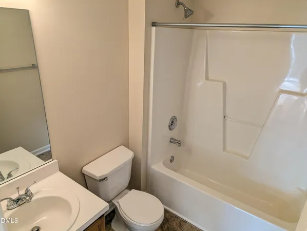 a white toilet sitting next to a bath tub