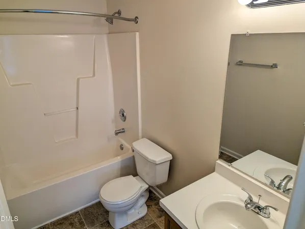 a white toilet sitting next to a bath tub