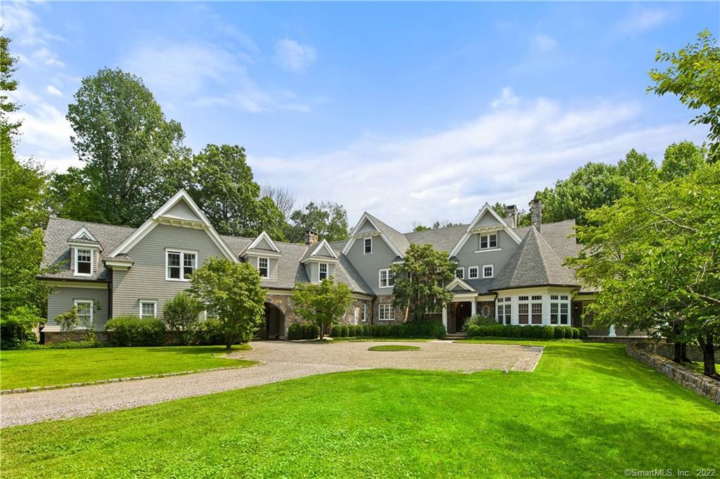 a front view of a house with a yard and potted plants