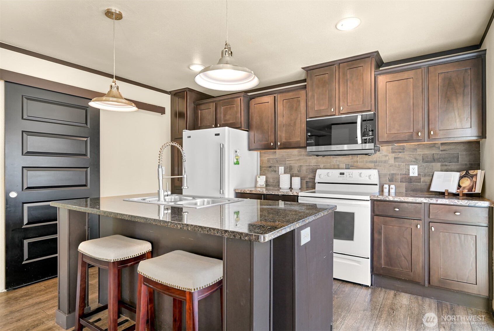 1229 West Axton Road Ferndale, WA 98248 - Photo 16 of 40 a kitchen with kitchen island a stove a table and chairs in it