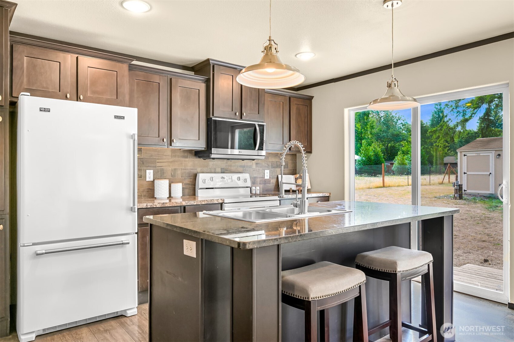 1229 West Axton Road Ferndale, WA 98248 - Photo 18 of 40 a kitchen with stainless steel appliances granite countertop a refrigerator a sink dishwasher a stove a refrigerator with island and chairs