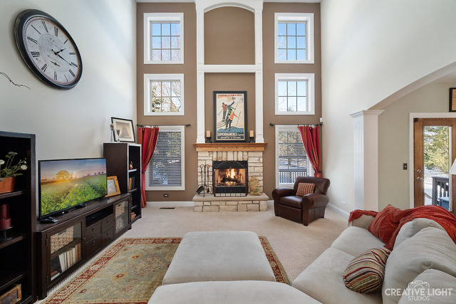 8 Winthrop New Road Sugar Grove, IL 60554 - Photo 10 of 38 a living room with furniture a flat screen tv and a fireplace