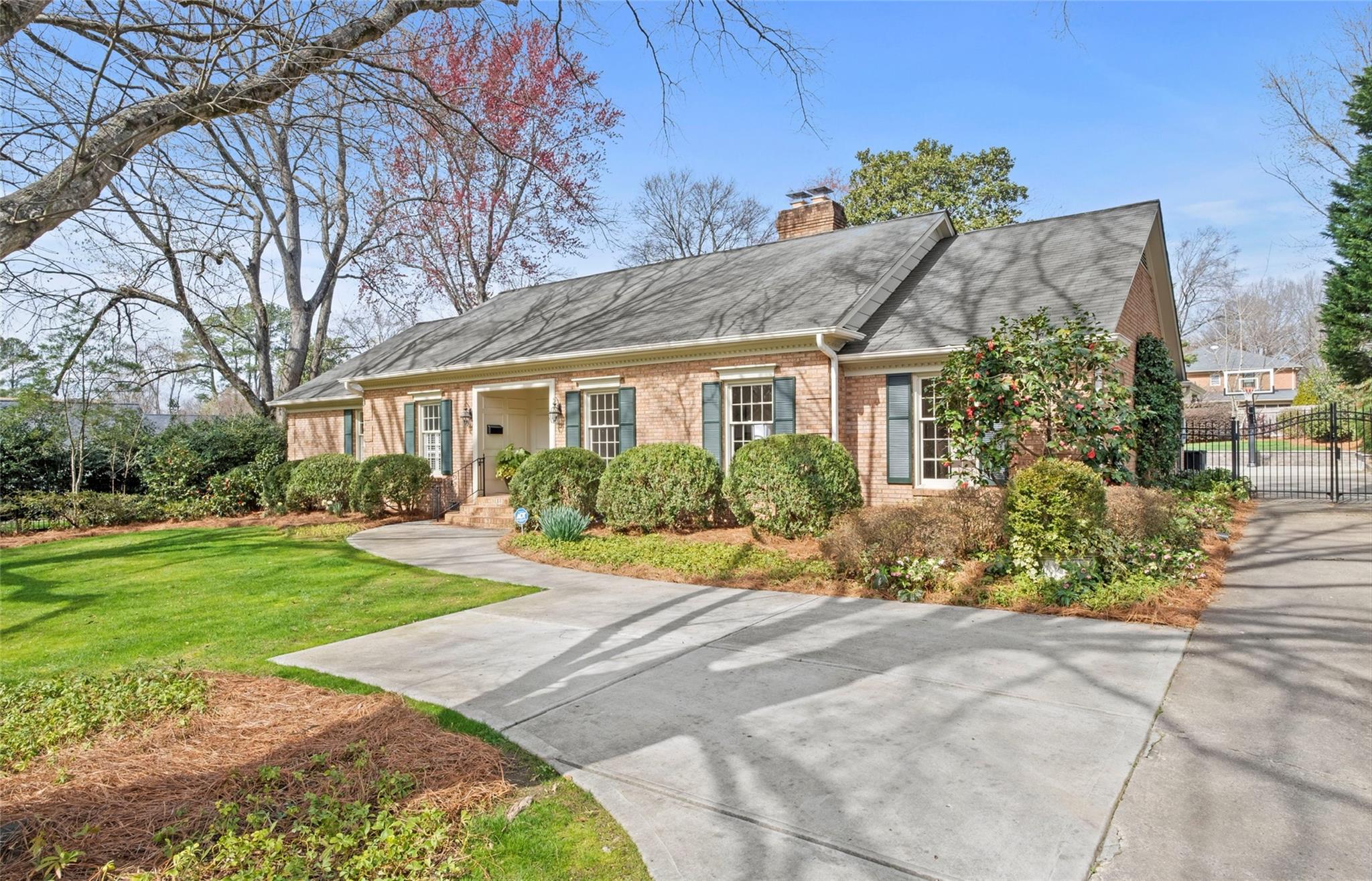 a front view of a house with a yard and potted plants