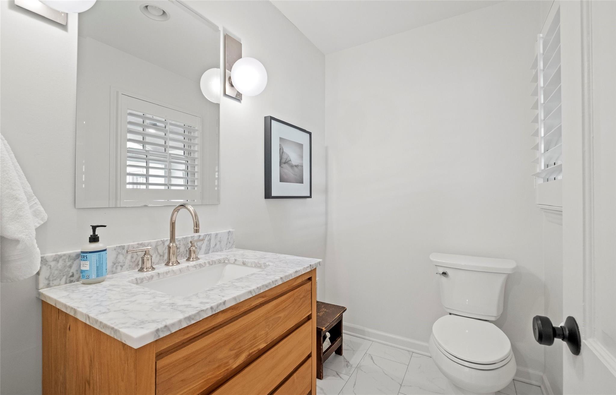 3136 Clarendon Road Charlotte, NC 28211 - Photo 21 of 47 a bathroom with a toilet a sink a mirror and a window