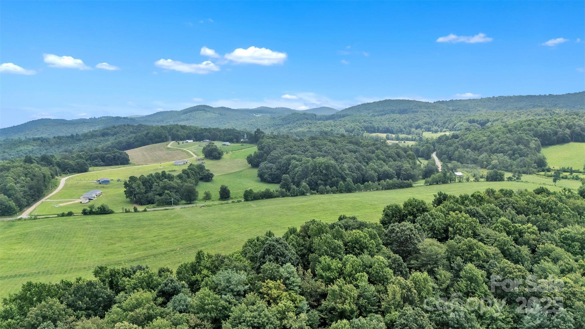 0 Pike Road Moravian Falls, NC 28654 - Photo 19 of 19 a view of a lush green outdoor space with a swimming pool and valleys in the background
