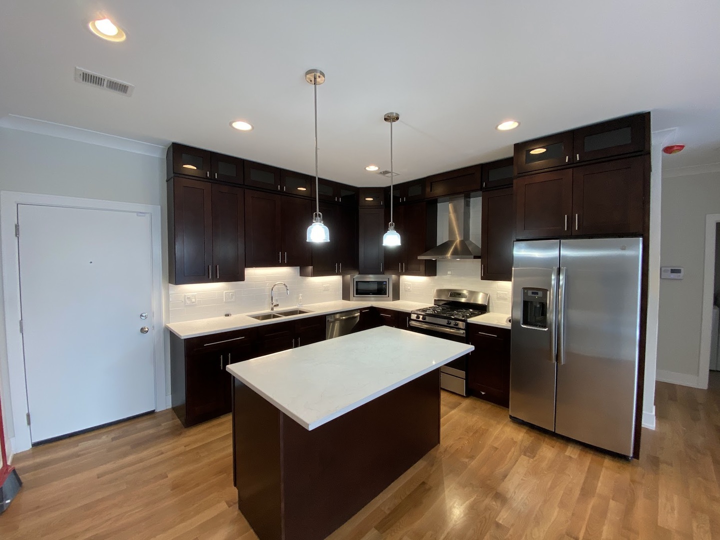 3203 North Ridgeway Avenue, Unit 2B Chicago, IL 60618 - Photo 3 of 15 a kitchen with a refrigerator a sink and wooden floor
