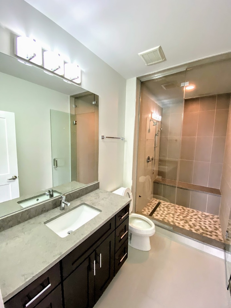 3203 North Ridgeway Avenue, Unit 2B Chicago, IL 60618 - Photo 8 of 15 a bathroom with a double vanity sink toilet mirror and bathtub