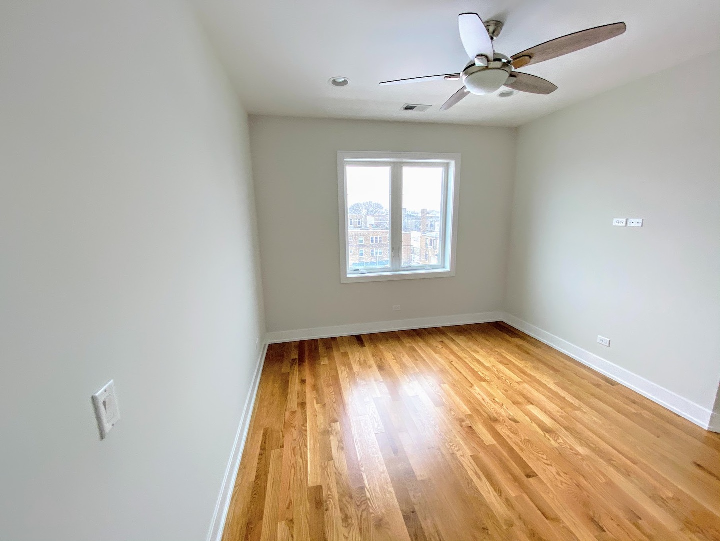 3203 North Ridgeway Avenue, Unit 2B Chicago, IL 60618 - Photo 10 of 15 a view of empty room with wooden floor and fan