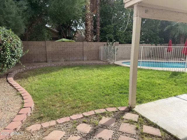 a view of a tennis ground with a chair under an umbrella