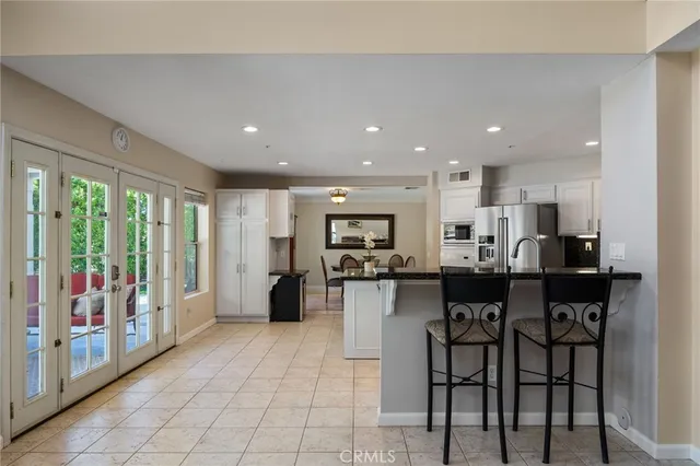a kitchen with stainless steel appliances kitchen island granite countertop a refrigerator and cabinets