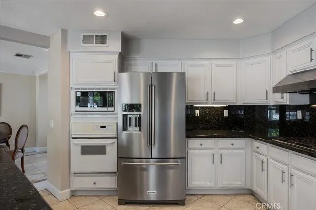 a kitchen with white cabinets and stainless steel appliances