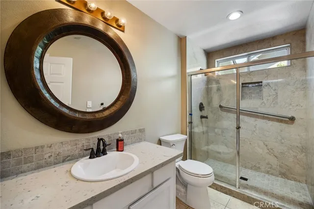 a bathroom with a sink a toilet and a mirror