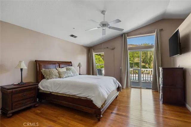 a bedroom with a large bed and a flat tv screen on a dresser