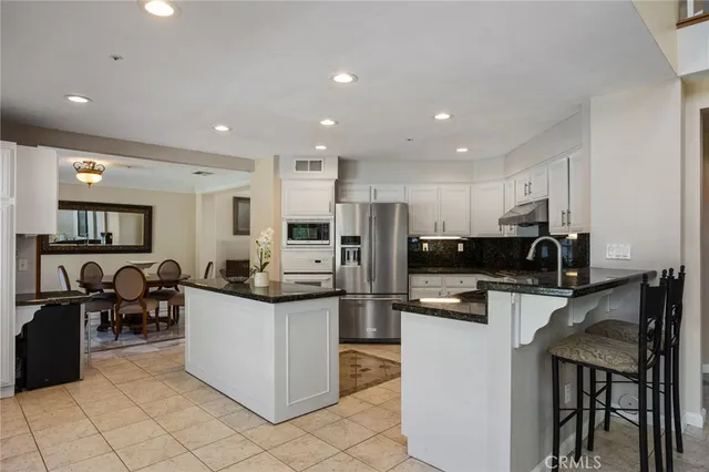 a kitchen with kitchen island a counter top space cabinets and stainless steel appliances