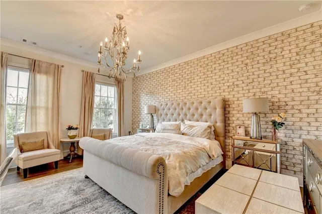 a bedroom with a bed next to a window and a chandelier