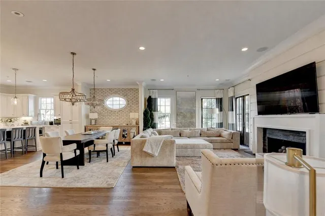 a living room with furniture kitchen view and a large window
