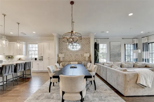 a kitchen with granite countertop a table chairs stove and cabinets