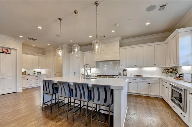 a kitchen with stainless steel appliances kitchen island a sink a stove a center island a window and cabinets